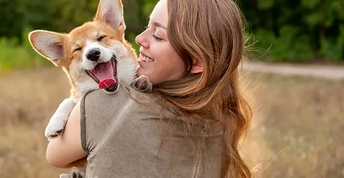 owner carrying dog over-the field